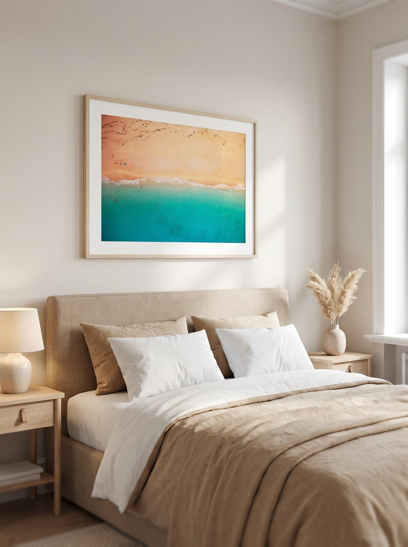Bedroom with Turquoise Tide aerial beach print in a natural-wood frame above the bed